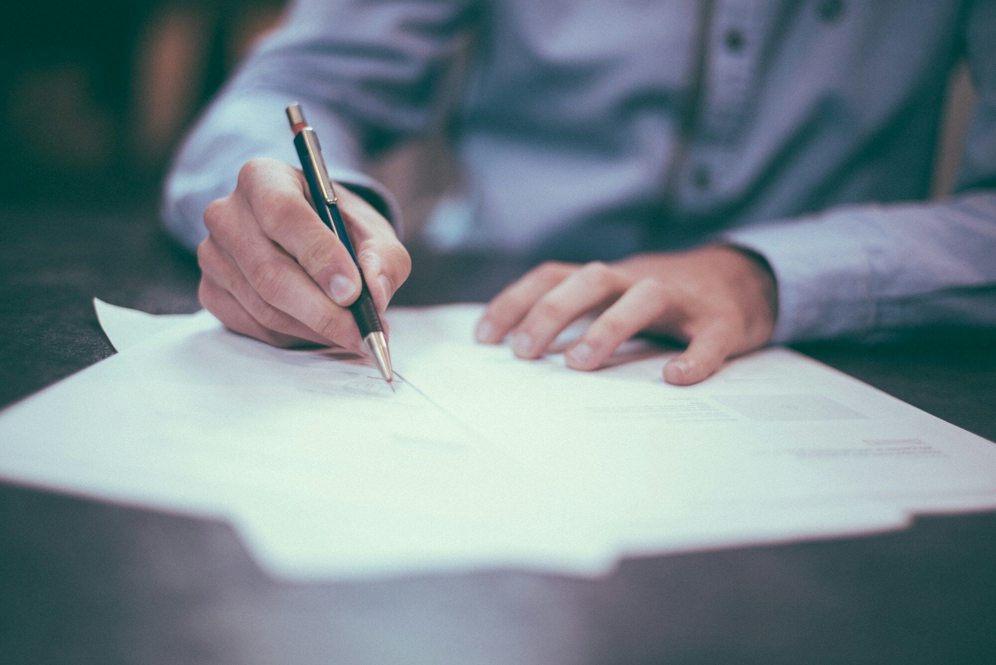 Someone signing a paper form